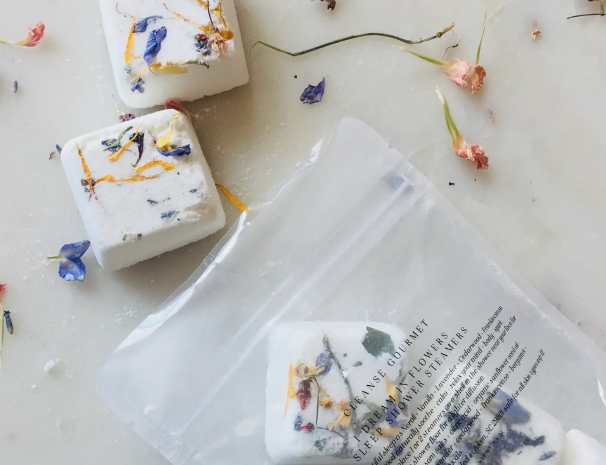 Cleanse Gourmet I Dream In Flowers Sleep Shower Steamers, white cubes with dried flower petals in a clear pouch