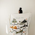 Clementine Kids Large Reversible National Parks Throw Blanket held up showing the illustrated parks map
