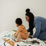 Mother and child playing on the Clementine Kids National Parks Throw Blanket on a bed