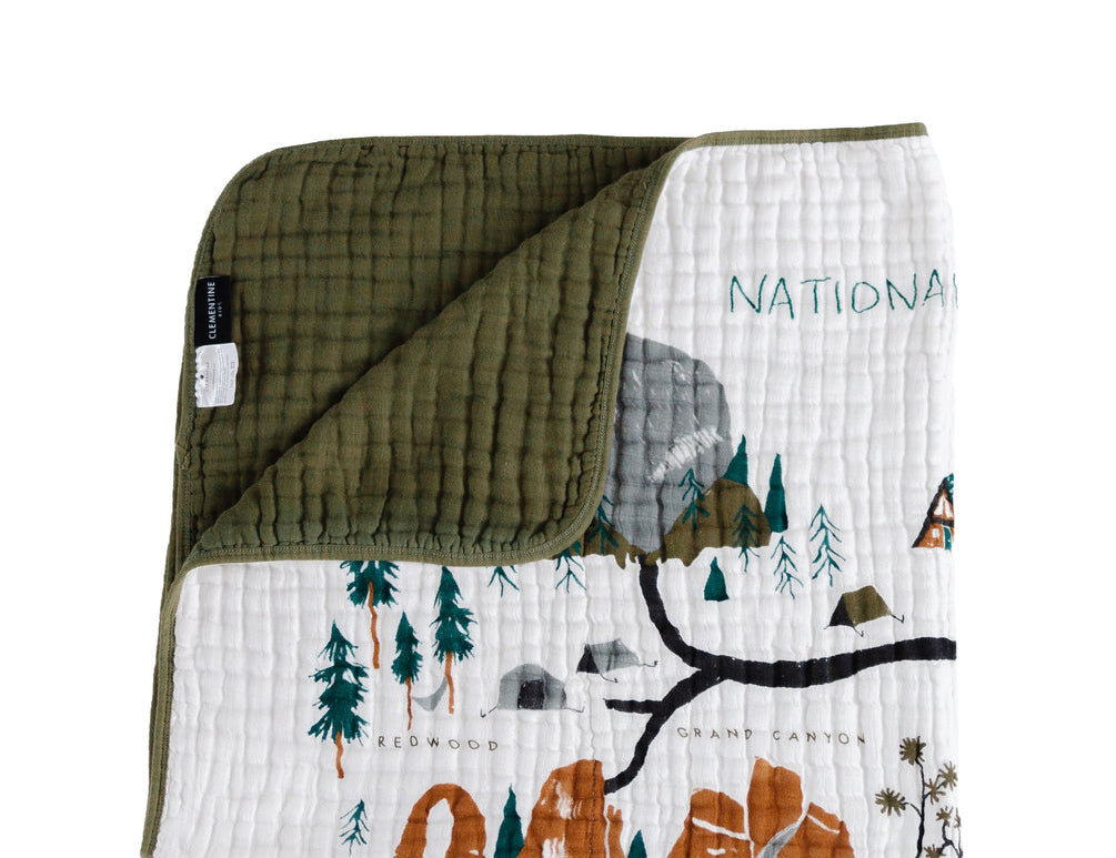Clementine Kids Reversible National Parks Quilt with an illustrated parks map and an olive green reverse