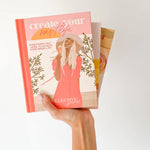 Hand holding the Collective Hub Create Your Best Life Journal showing its colorful page edges