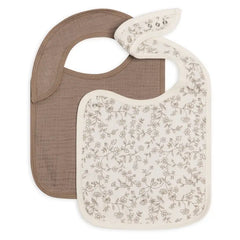 Colored Organics 2-Pack Muslin Bib in Pip Floral Ivory and Taupe, one solid taupe bib and one ivory bib with a small brown floral print, on white