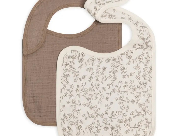 Colored Organics 2-Pack Muslin Bib in Pip Floral Ivory and Taupe, one solid taupe bib and one ivory bib with a small brown floral print, on white