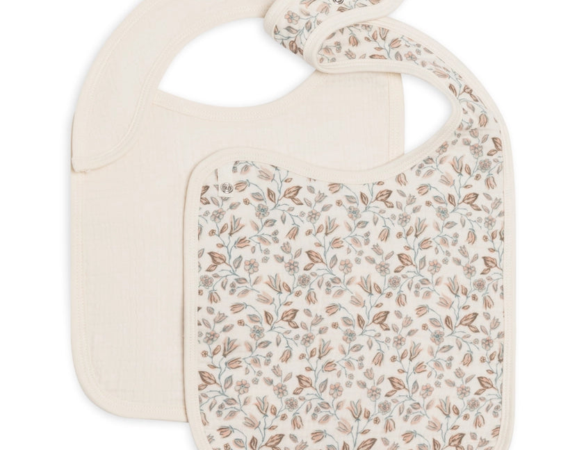 Colored Organics 2-Pack Muslin Bib in Yuma Floral and Ivory, one solid ivory bib and one ivory bib with a small rust and sage leaf print, on white