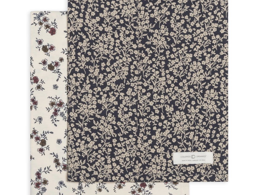 Colored Organics 2-Pack Organic Baby Burp Cloths in Poppy and Chicory Floral, one cream floral cloth and one navy cloth with a dense white floral print