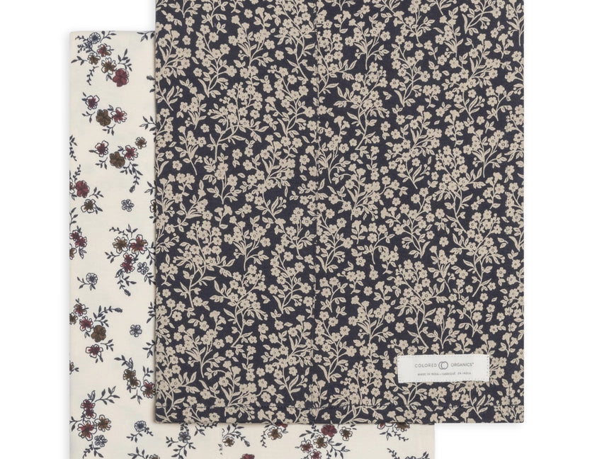 Colored Organics 2-Pack Organic Baby Burp Cloths in Poppy and Chicory Floral, one cream floral cloth and one navy cloth with a dense white floral print