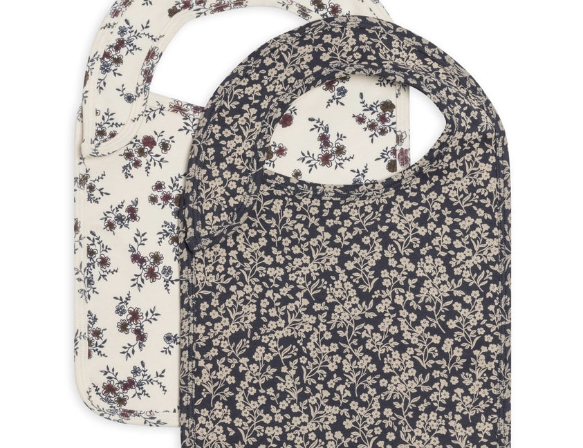 Colored Organics Organic 2-Pack Bibs in Poppy and Chicory Floral, a cream floral bib and a navy floral bib