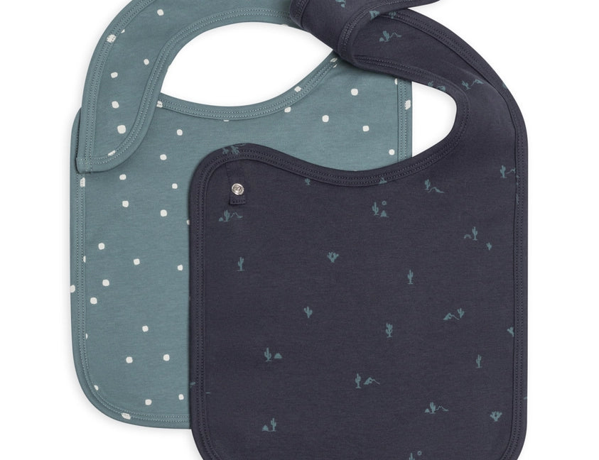 Colored Organics Organic 2-Pack Bibs in Square Dot and Cactus Navy, a teal dot bib and a navy cactus bib