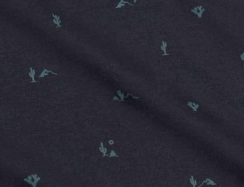 Close-up of the small teal cactus print on the navy Colored Organics Organic Baby Swaddle Blanket in Cactus