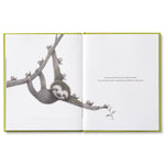 Compendium Being Kind book open to a page of a sloth hanging from a branch holding a flower