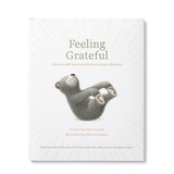 Compendium Feeling Grateful book cover with a gray bear lying on its back on a white sunburst background