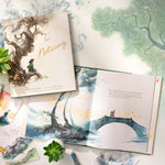 Compendium Noticing book with an open copy on a watercolor background with leaves