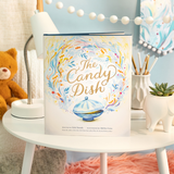 Compendium The Candy Dish book on a white nightstand with a teddy bear and lamp