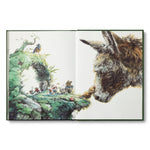 Compendium The Storyteller's Almanac open to a watercolor of a donkey meeting tiny characters on a mossy hill