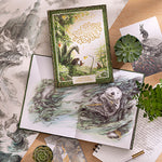 Compendium The Storyteller's Almanac book displayed with open pages, a succulent and pencils