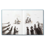 Compendium Trying book open to an illustration of animals gathered watching a child at work