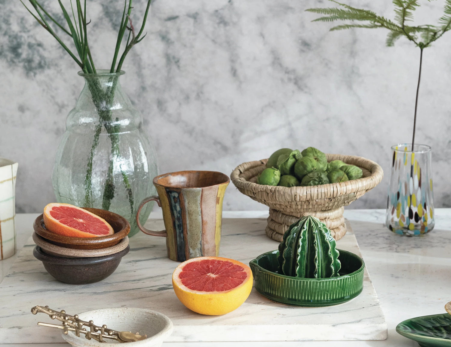 Creative Co-Op Stoneware Cactus Juicer on a kitchen counter with grapefruit halves and a bowl of limes