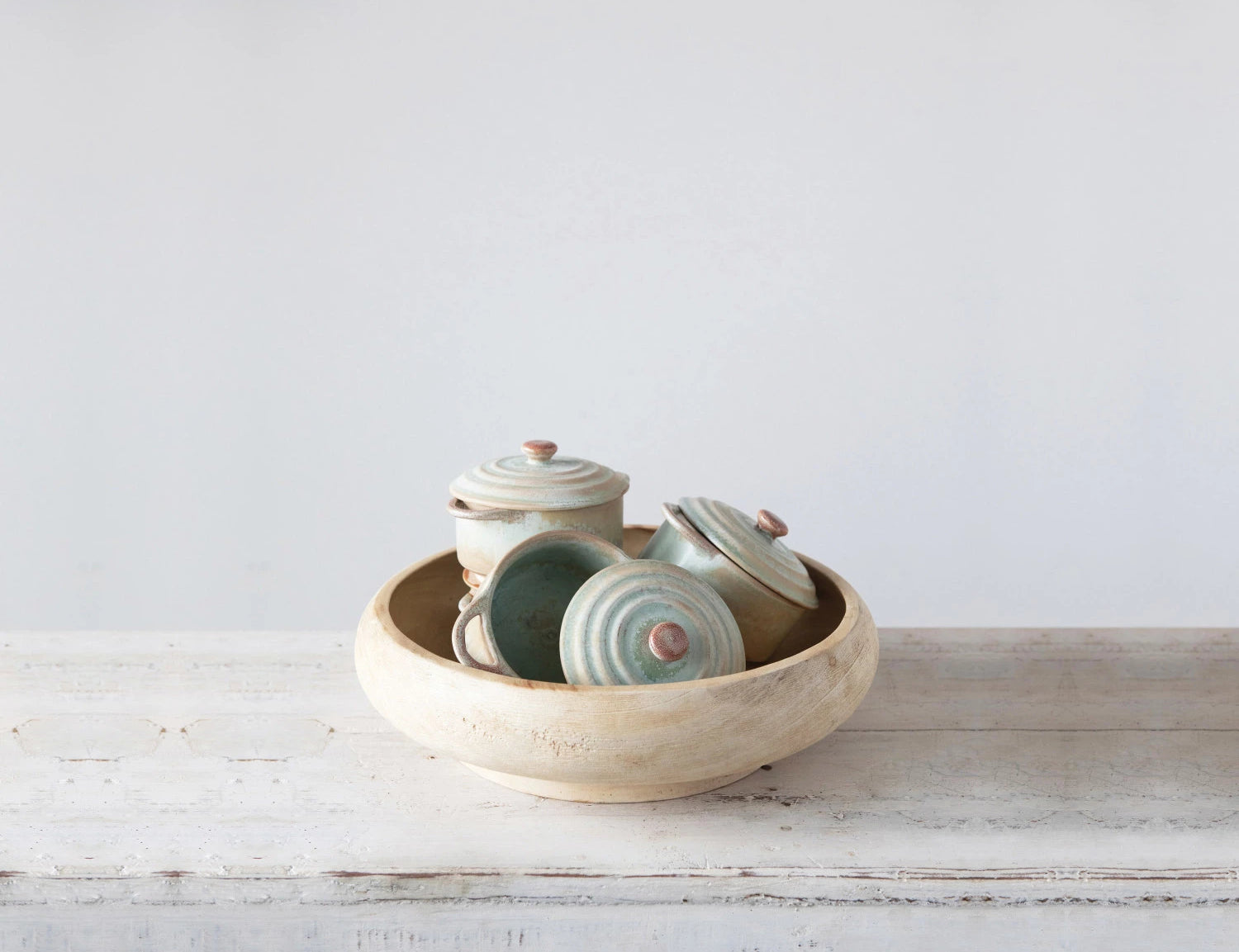 Creative Co-Op Stoneware Mini Bakers stacked inside a larger bowl on a rustic table