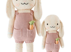 Cuddle + Kind Harper the Bunny, a hand-knit cream bunny doll in pink overalls holding a carrot, shown in two sizes