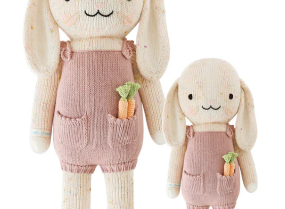 Cuddle + Kind Harper the Bunny, a hand-knit cream bunny doll in pink overalls holding a carrot, shown in two sizes