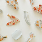 Desert Sol Apricot Floral and Muted Moss acrylic claw clips and snap clips scattered on cream