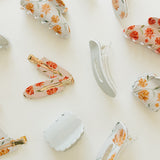 Desert Sol Apricot Floral and Muted Moss acrylic claw clips and snap clips scattered on cream