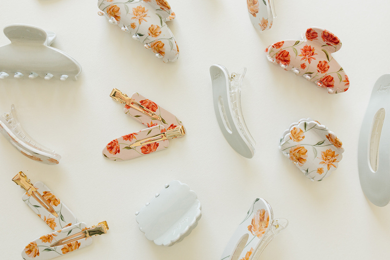 Desert Sol Apricot Floral and Muted Moss acrylic claw clips and snap clips scattered on cream