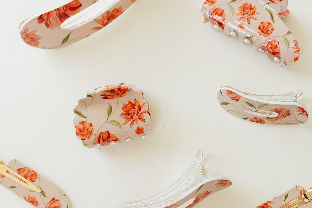 Desert Sol Brushed Sand Floral acrylic hair clip set with an oval lay flat claw clip, classic claw clip, petal claw clip and snap clips with red and coral flowers
