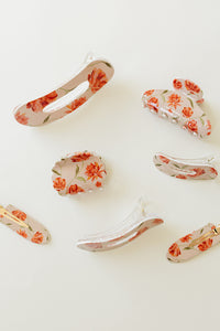 Desert Sol Brushed Sand Floral acrylic hair clip set with an oval lay flat claw clip, classic claw clip, petal claw clip and snap clips with red and coral flowers