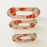 Desert Sol Oval Lay Flat Acrylic Claw Clip in Brushed Sand Floral, shown in Mini, Standard and Classic sizes
