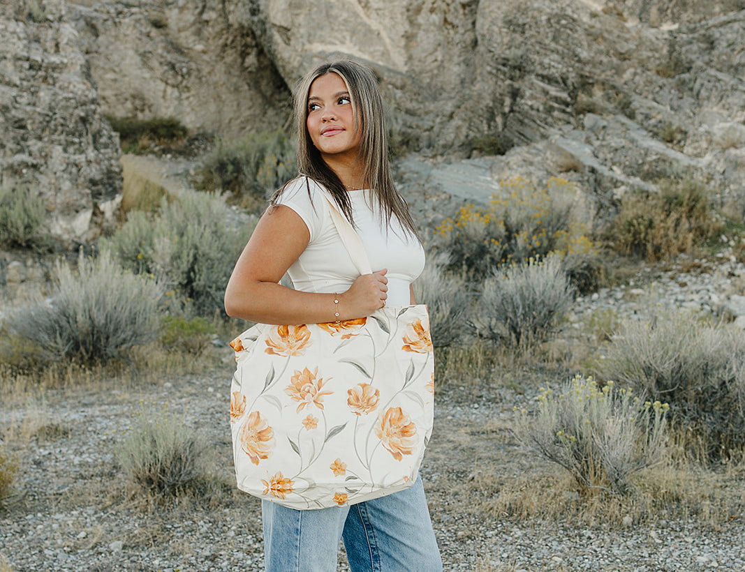 Model carrying the Desert Sol Carryall Tote in Apricot Floral