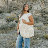 Model carrying the Desert Sol Carryall Tote in Canyon Rose in the desert