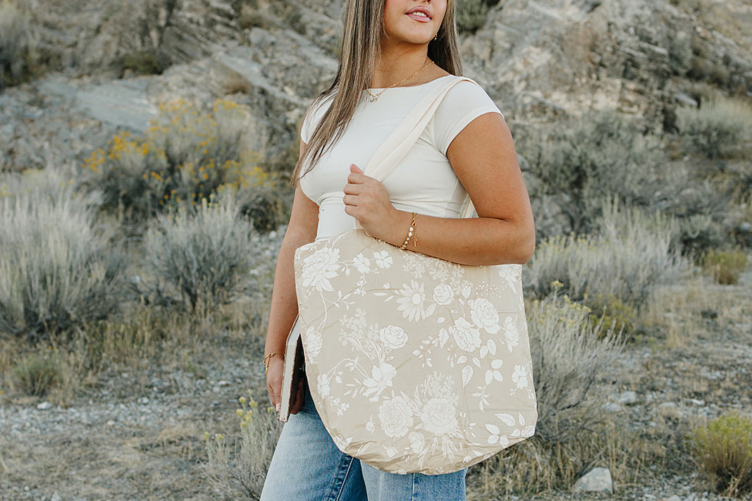 Model carrying the Desert Sol Carryall Tote in Canyon Rose in the desert