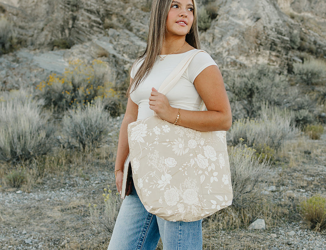 Model carrying the Desert Sol Carryall Tote in Canyon Rose in the desert