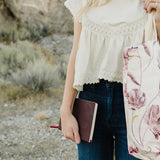 Desert Sol Carryall Tote in Mulberry Floral with the Desert Plum vegan leather journal in hand