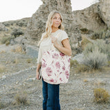 Model carrying the Desert Sol Carryall Tote in Mulberry Floral on her shoulder
