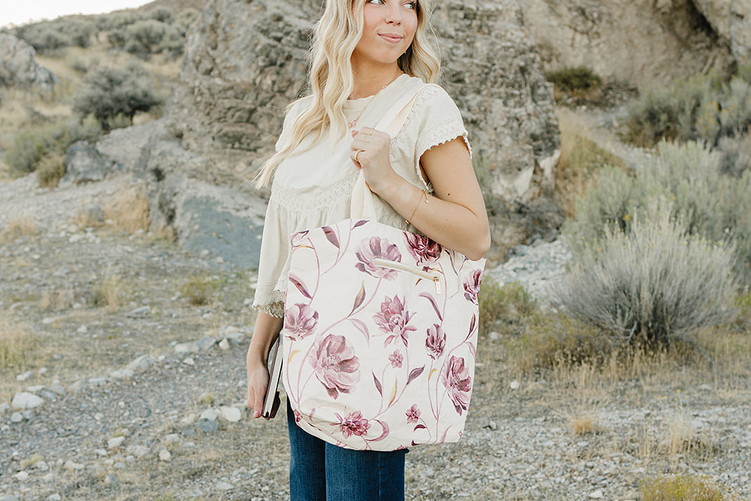 Model carrying the Desert Sol Carryall Tote in Mulberry Floral on her shoulder