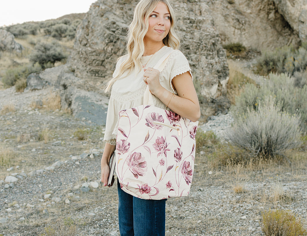 Model carrying the Desert Sol Carryall Tote in Mulberry Floral on her shoulder