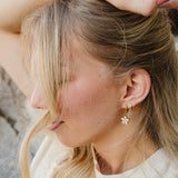 Close up of the Desert Sol Dainty Hoop Earrings in gold with a crystal flower drop