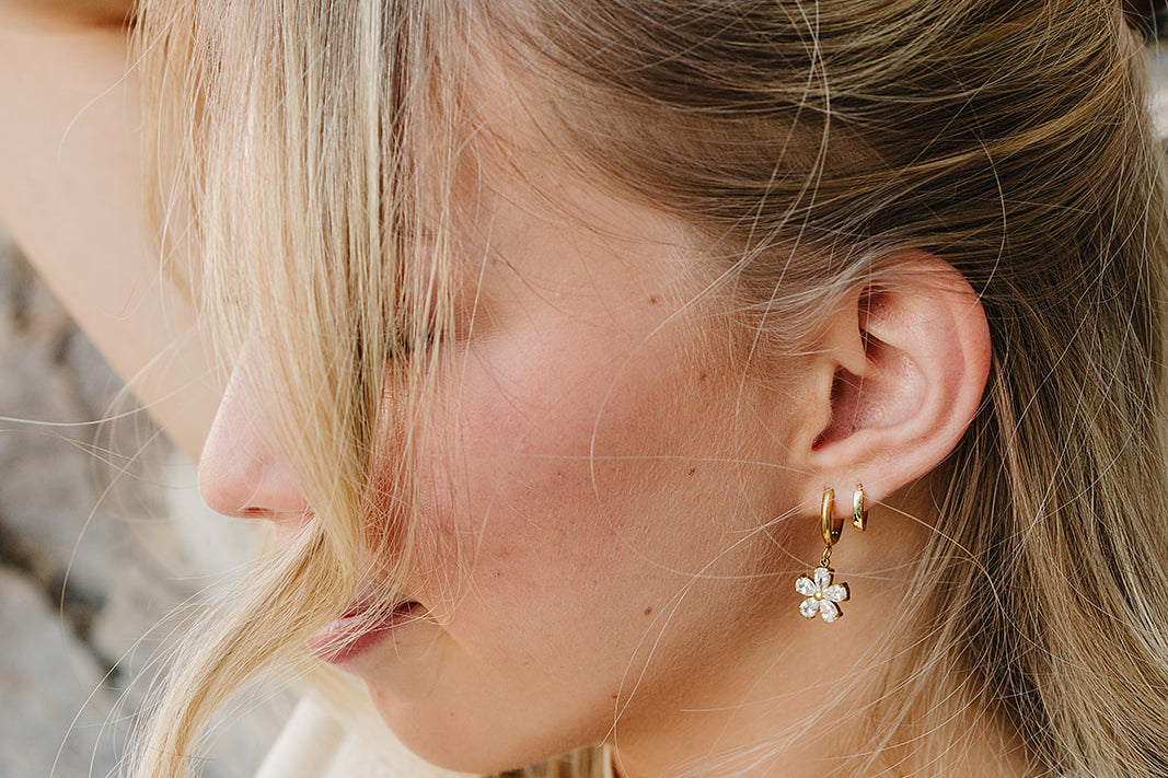 Close up of the Desert Sol Dainty Hoop Earrings in gold with a crystal flower drop