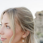 Close up of the Desert Sol Dainty Hoop Earrings in gold on a model with long blonde waves