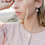 Model wearing the Desert Sol Dainty Hoop Earrings in silver with a crystal flower drop