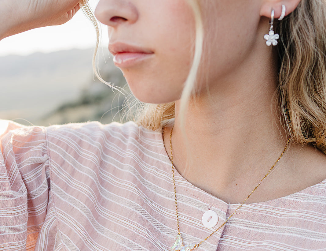 Model wearing the Desert Sol Dainty Hoop Earrings in silver with a crystal flower drop