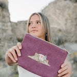 Model holding the Desert Sol Desert Mesa corduroy medium pouch in plum