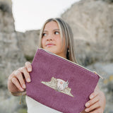 Model holding the Desert Sol Desert Mesa corduroy medium pouch in plum