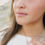 Close up of the Desert Sol Ember Butterfly Necklace in Blush Pink on a delicate gold chain
