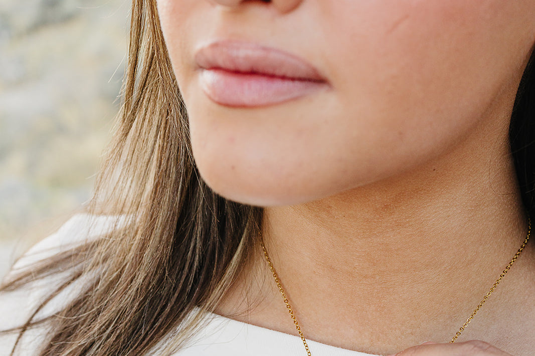 Close up of the Desert Sol Ember Butterfly Necklace in Blush Pink on a delicate gold chain