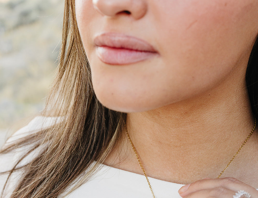 Close up of the Desert Sol Ember Butterfly Necklace in Blush Pink on a delicate gold chain