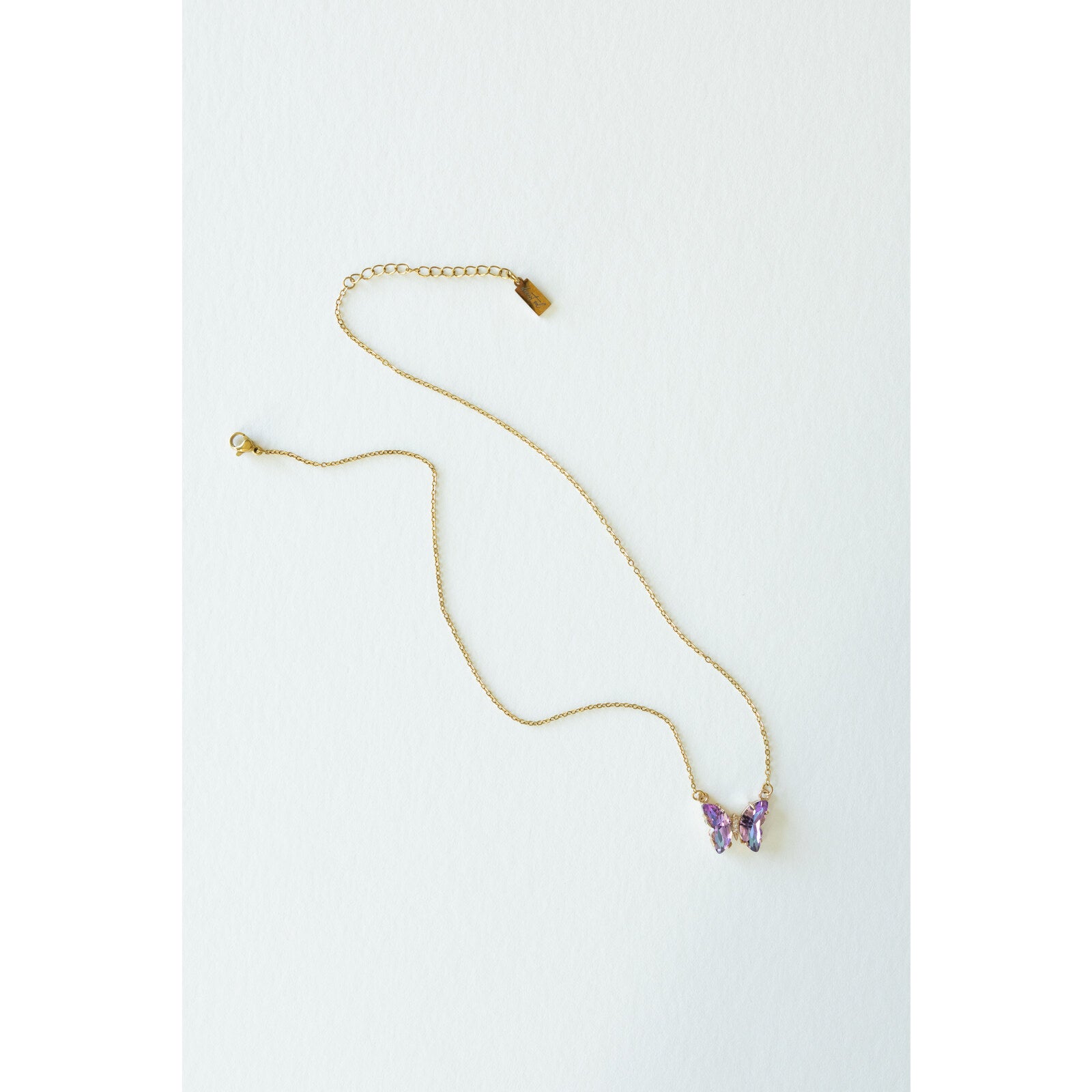 Desert Sol Ember Butterfly Necklace in lavender prism, a faceted crystal butterfly pendant on a warm gold chain, on a white background