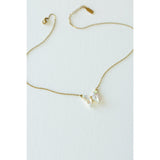 Desert Sol Ember Butterfly Necklace in opal white, a faceted crystal butterfly pendant on a warm gold chain, on a white background